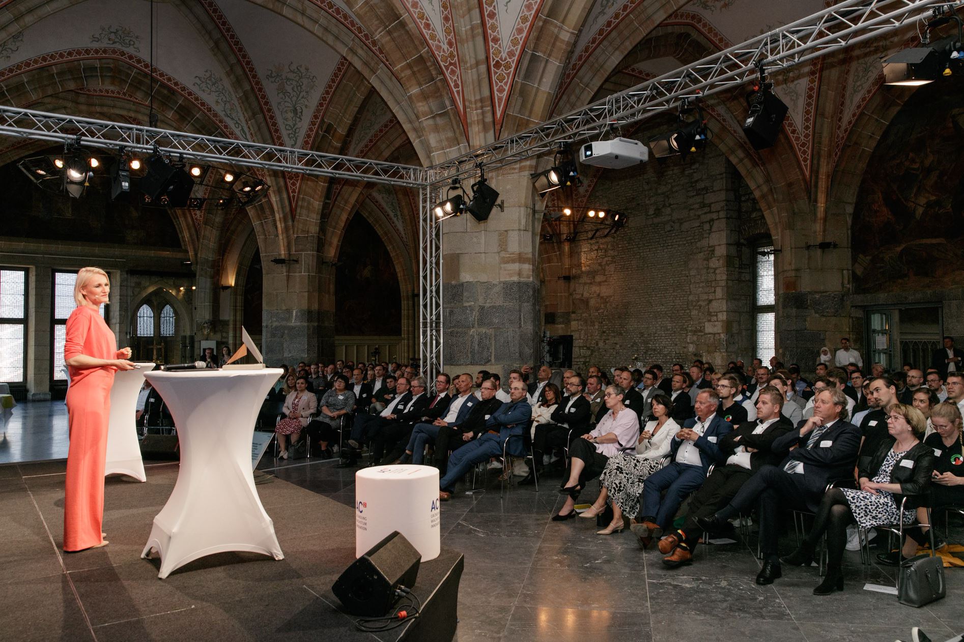 Henriette Hochstein-Frädrich, author of Quit the Feed!, giving a keynote in a historic vaulted town hall to a full audience of business leaders