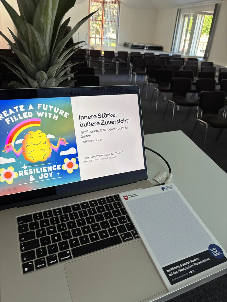 Laptop mit Titelfolie „Innere Stärke, äußere Zuversicht — Resilienz & Mut durch volatile Zeiten" beim Vortrag im Finanzamt Wolfenbüttel