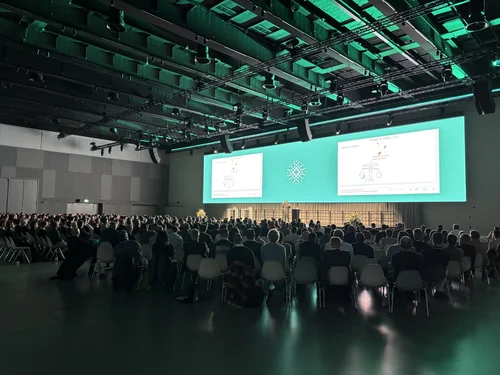 Bühne des Fernwärme-Forums 2026 in Bern mit zwei großen Projektionsleinwänden während der Keynote